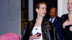 sarah paulson wearing a white vest and varsity jacket 