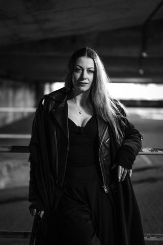 Black-and-white image of a person wearing a leather jacket and holding a cane, in an urban environment, taken on the Leica SL3-S with a Leica Summilux SL 50mm f/1.4 Asph lens