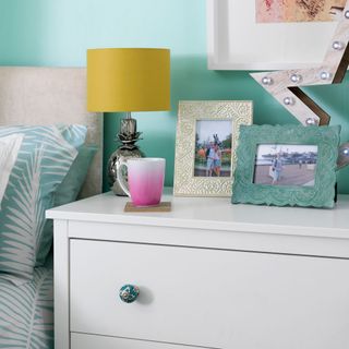 turquoise bedroom with white table and lamp