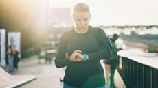 How often should you workout? Image shows woman looking at smartwatch