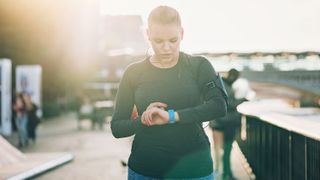 How often should you workout? Image shows woman looking at smartwatch