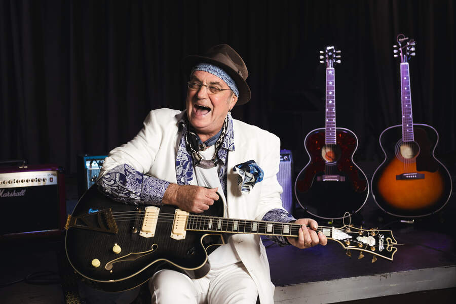 Terry Reid laughing while holding a guitar