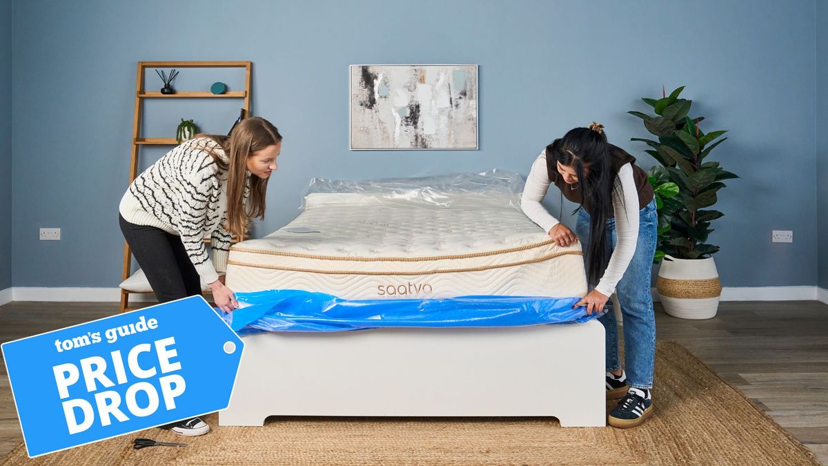 Two Tom&#039;s Guide mattress testers unpackaging the Saatva Classic in a minimalist bedroom