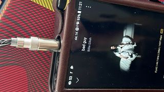 FiiO FH19 wired earbuds plugged into a music player playing Billie Eilish