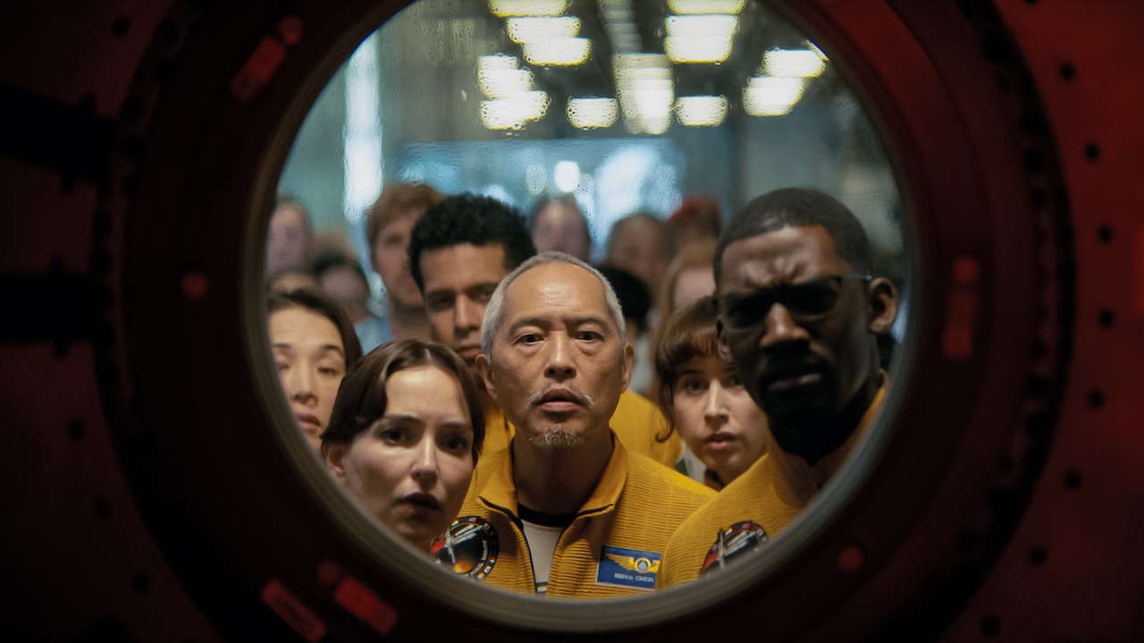 Milana Vayntrub stars as Olesya Ilyukhina and Ken Leung as Yao in standing at a circular window in Project Hail Mary