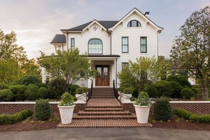 brick walkway to white victorian style house