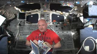 Endeavour shuttle commander and veteran astronaut Mark kelly displays the 2010-2011 yearbook of Mesa Verde Elementary School in Tucson, Ariz., which he carried to space with him on Endeavour's final spaceflight in May 2011. This still was taken from a May 22 broadcast.