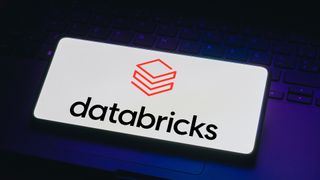Databricks logo displayed on a smartphone screen placed on laptop keyboard.