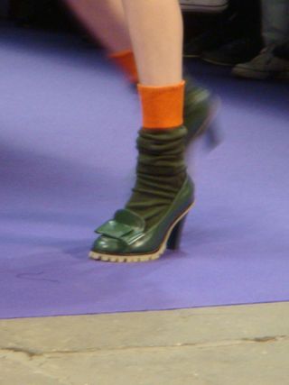 Green high-heeled shoes with matching bow, and green and orange socks