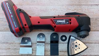 einhell multi tool and some attachments on wooden surface
