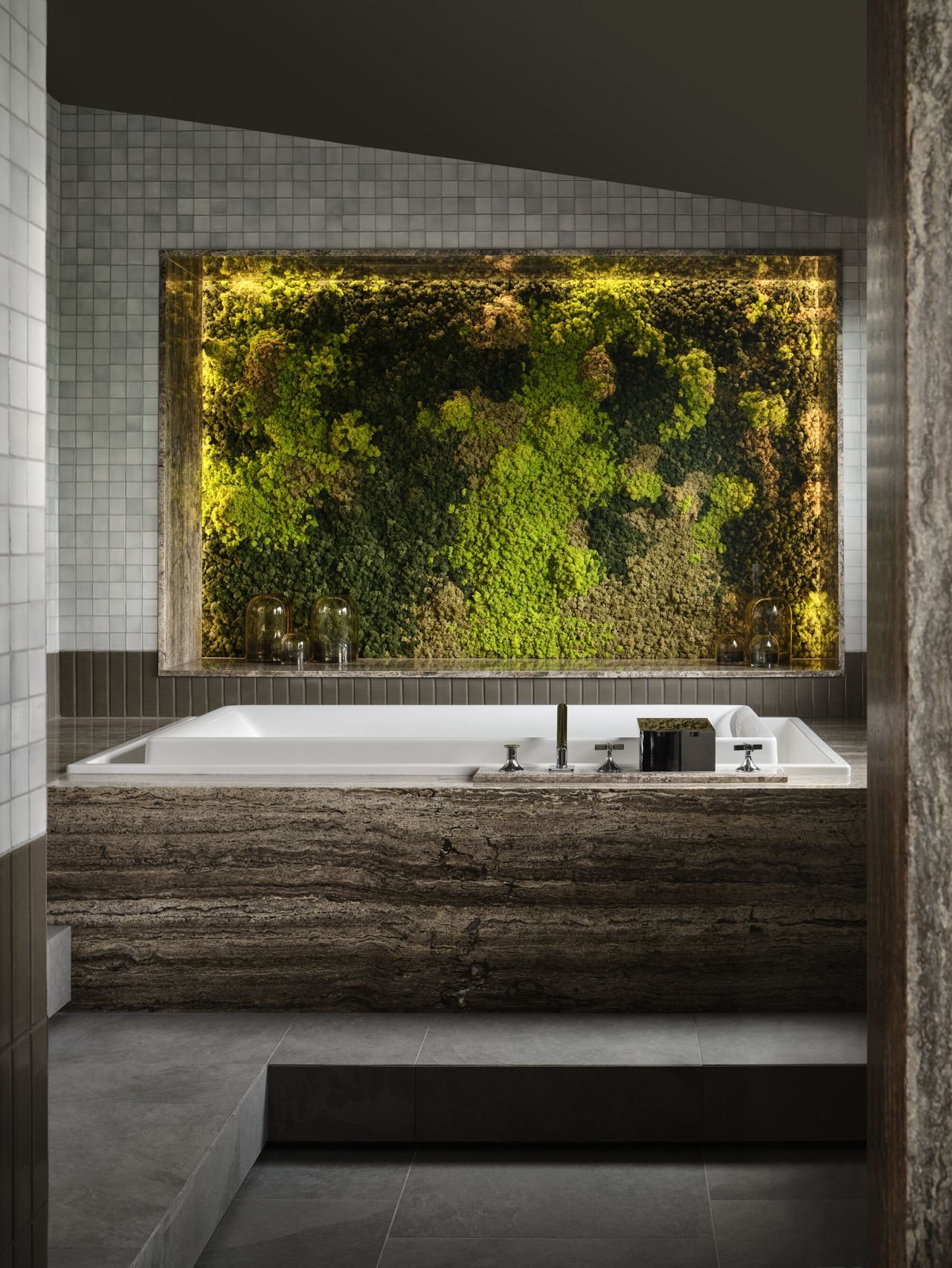 modern bathroom with gray floor tiles, gray zellige wall tiles, dark marble clad bath with living wall of preserved greenery on the wall
