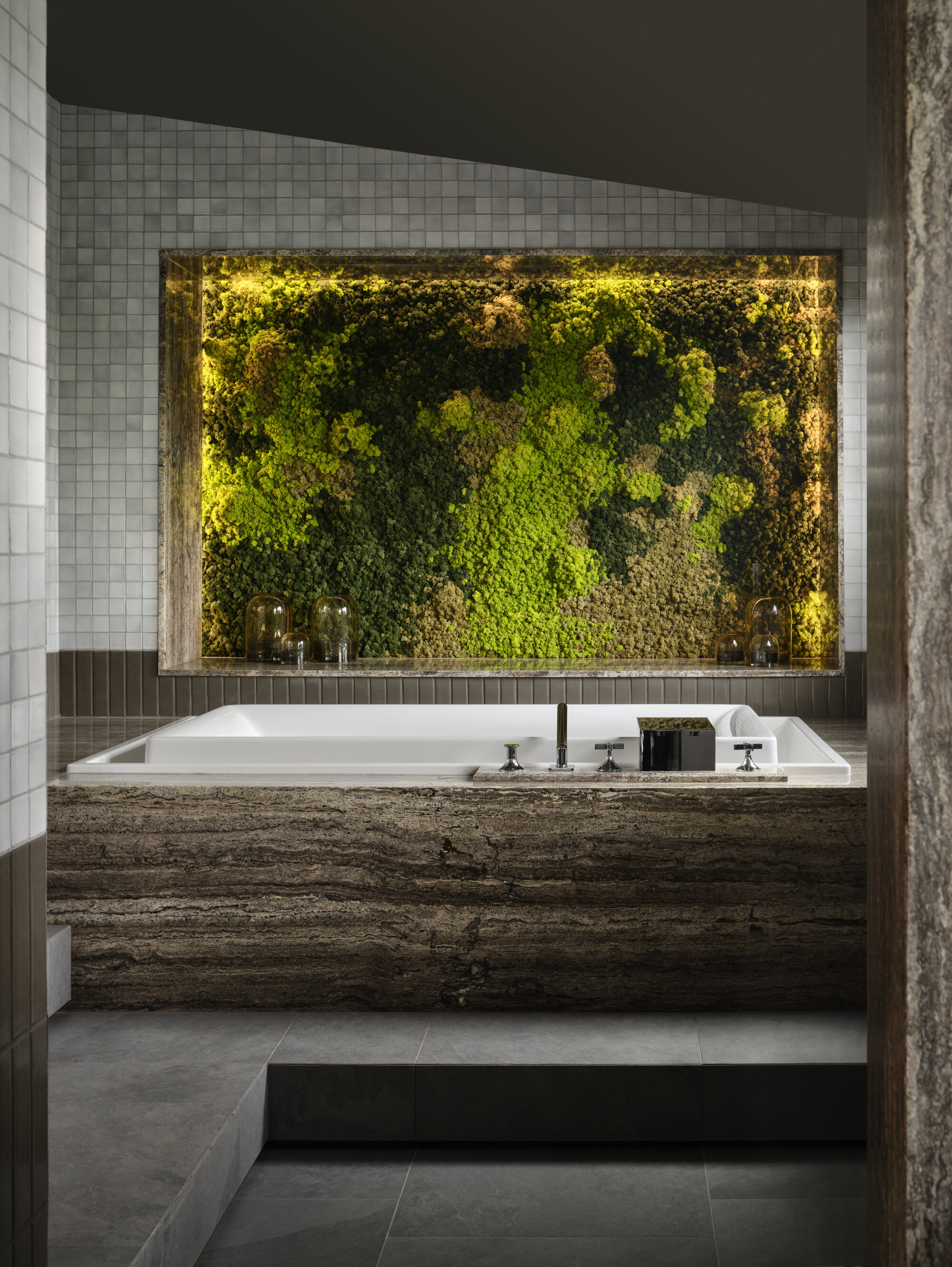 modern bathroom with gray floor tiles, gray zellige wall tiles, dark marble clad bath with living wall of preserved greenery on the wall