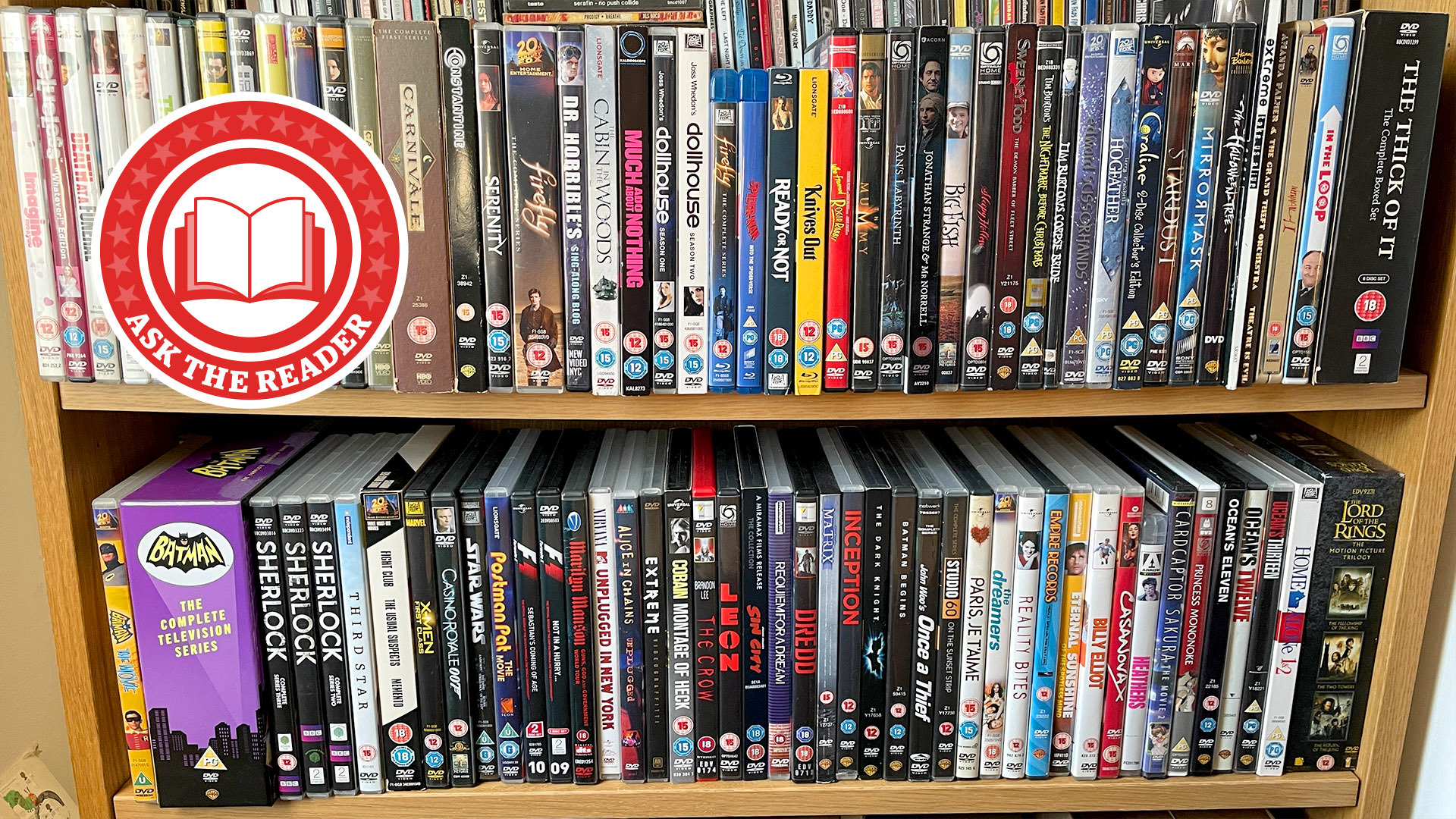 Two shelves of DVDs, with a round red sticker which reads 'Ask the Reader' in the corner edited on.