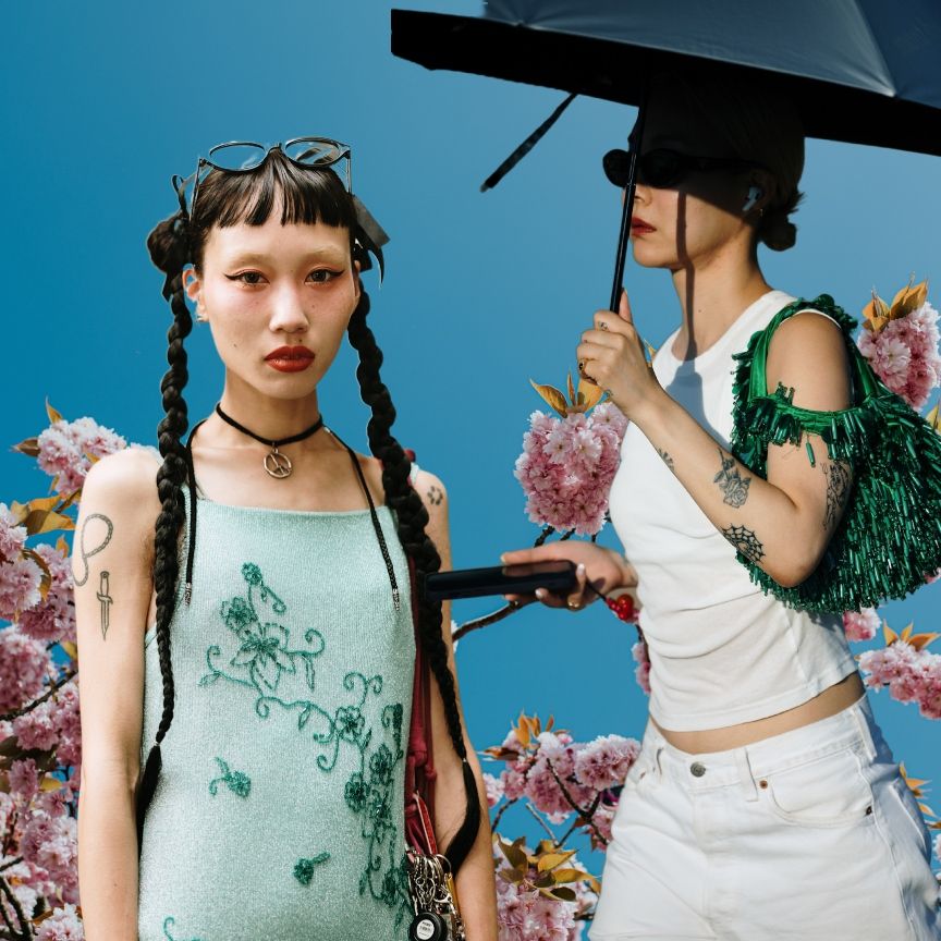 two Japanese women on a blue background with pink cherry blossom flowers