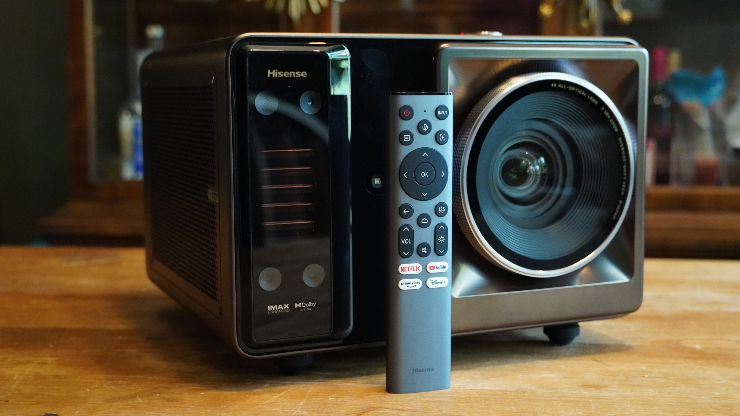 The remote control is leaning against the front of the Hisense XR10 projector.