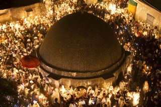 Candles lit by sacred fire light up the Church of the Holy Sepulchre in Jerusalem in April 2011. The church is said to be built over the original burial place of Jesus Christ. The structure in the middle of the dome is the Holy Edicule, which is built dir