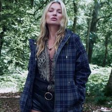 Kate moss wears a flannel jacket, blouse and belt with shorts.