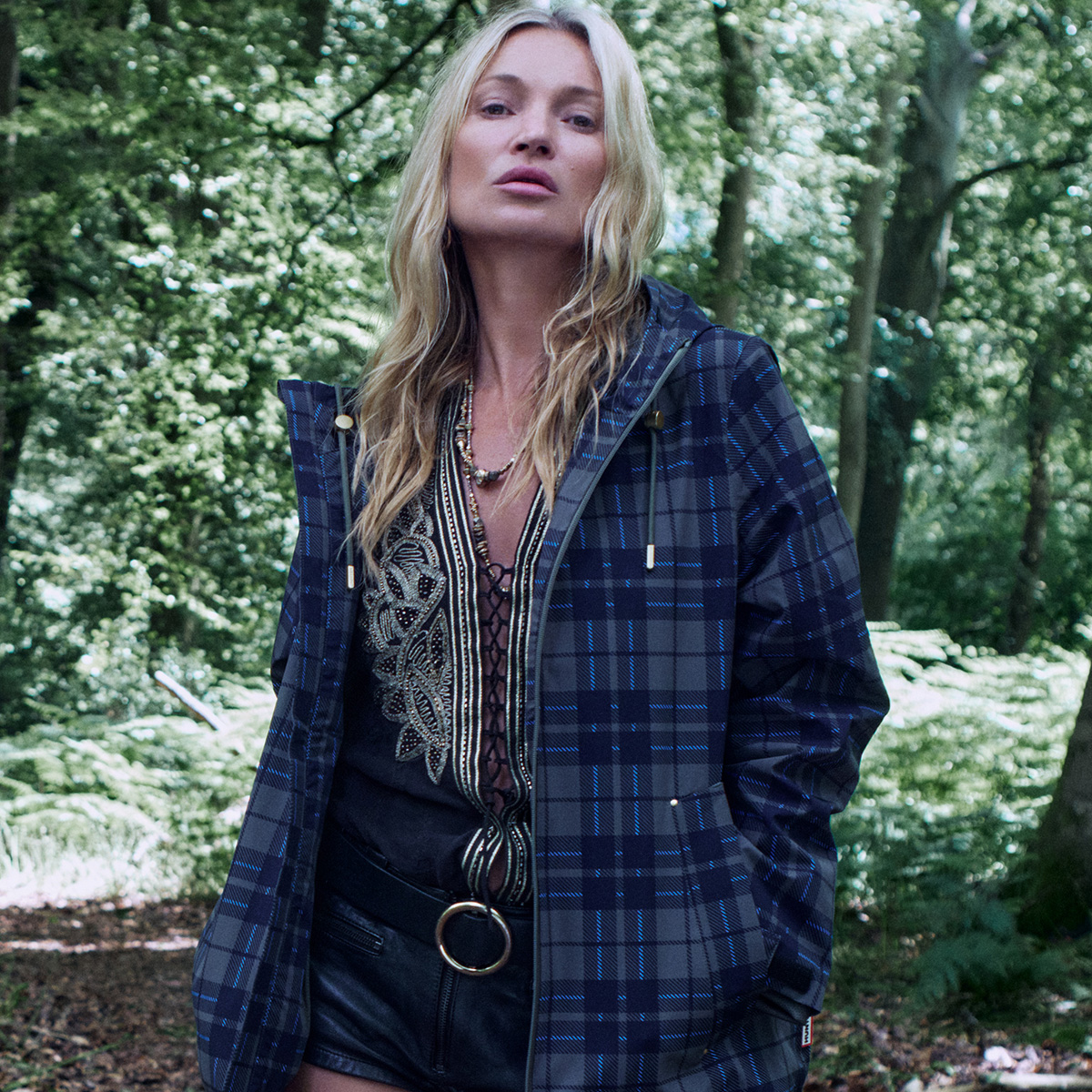 Kate moss wears a flannel jacket, blouse and belt with shorts.