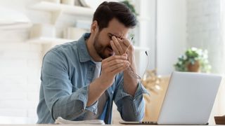 Man looking frustrated in front of laptop