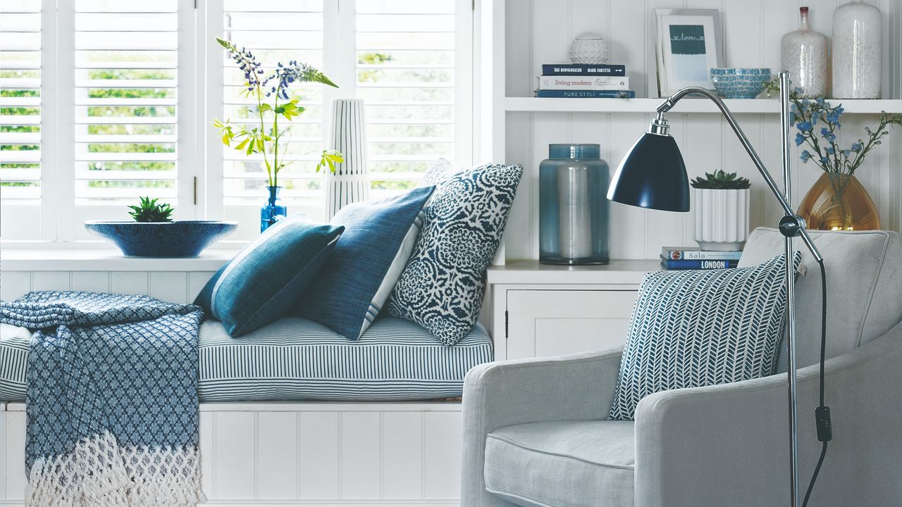 A white and blue livin groom with a window seat and built-in storage around the windows