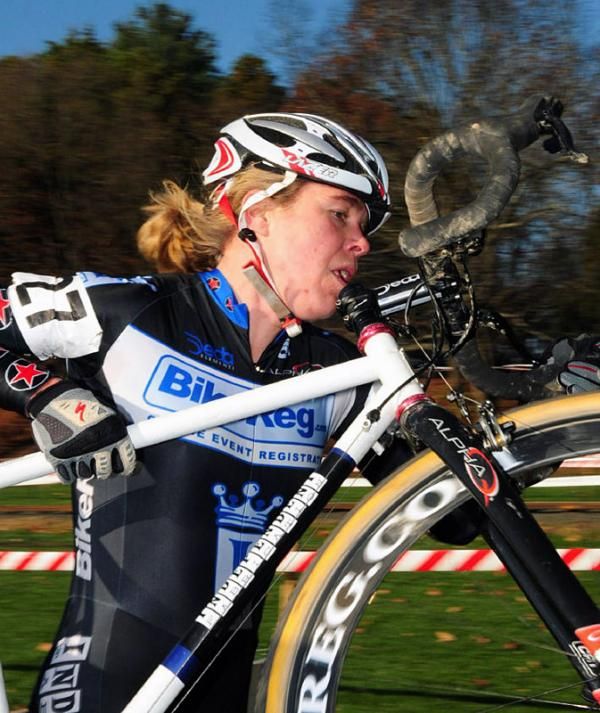 Anna Milkowski (Bike Reg) lifting her bike high over the barriers.