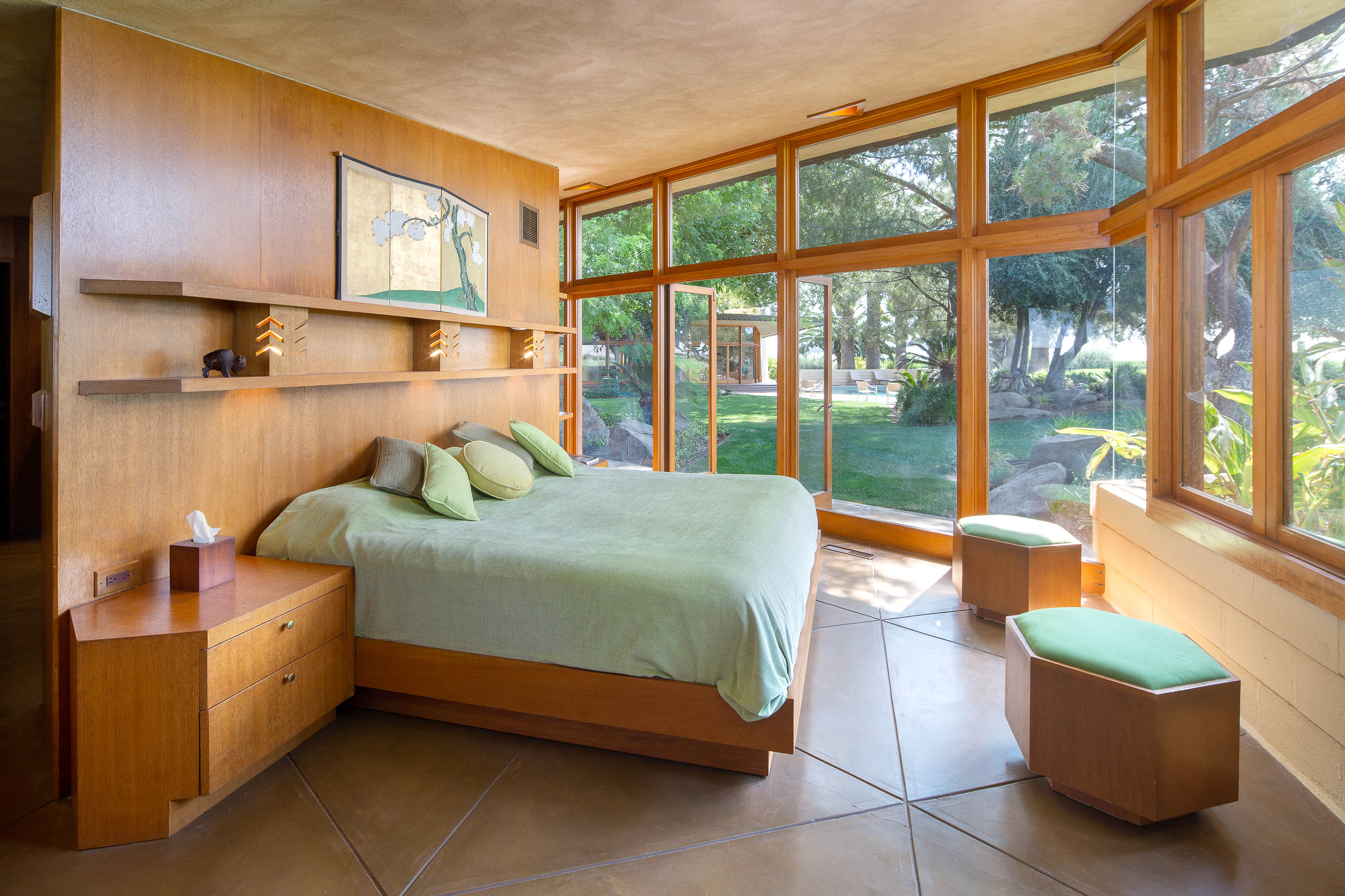 A bedroom with large windows and tiled floors