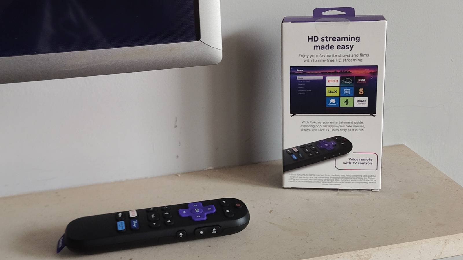 The Roku Streaming Stick remote next to its box.