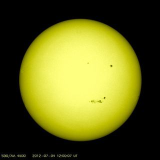This visible light image of the sun on July 4, 2012, shows the location of several sunspot patches on the sun's surface. The large sunspot group on the bottom of the sun is sunspot AR1515, an active region 100,000 km long. NASA's Solar Dynamics Observatory provided this view.