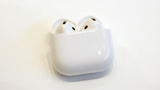 Apple AirPods 4 in the case on a white tabletop