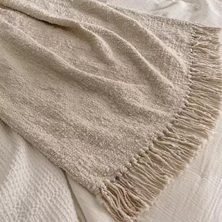 A boucle throw blanket draped across a bed