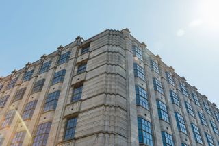 The Bungehuis’ limestone and granite-clad facade features art deco detailing image from outside on the corner, blue sky