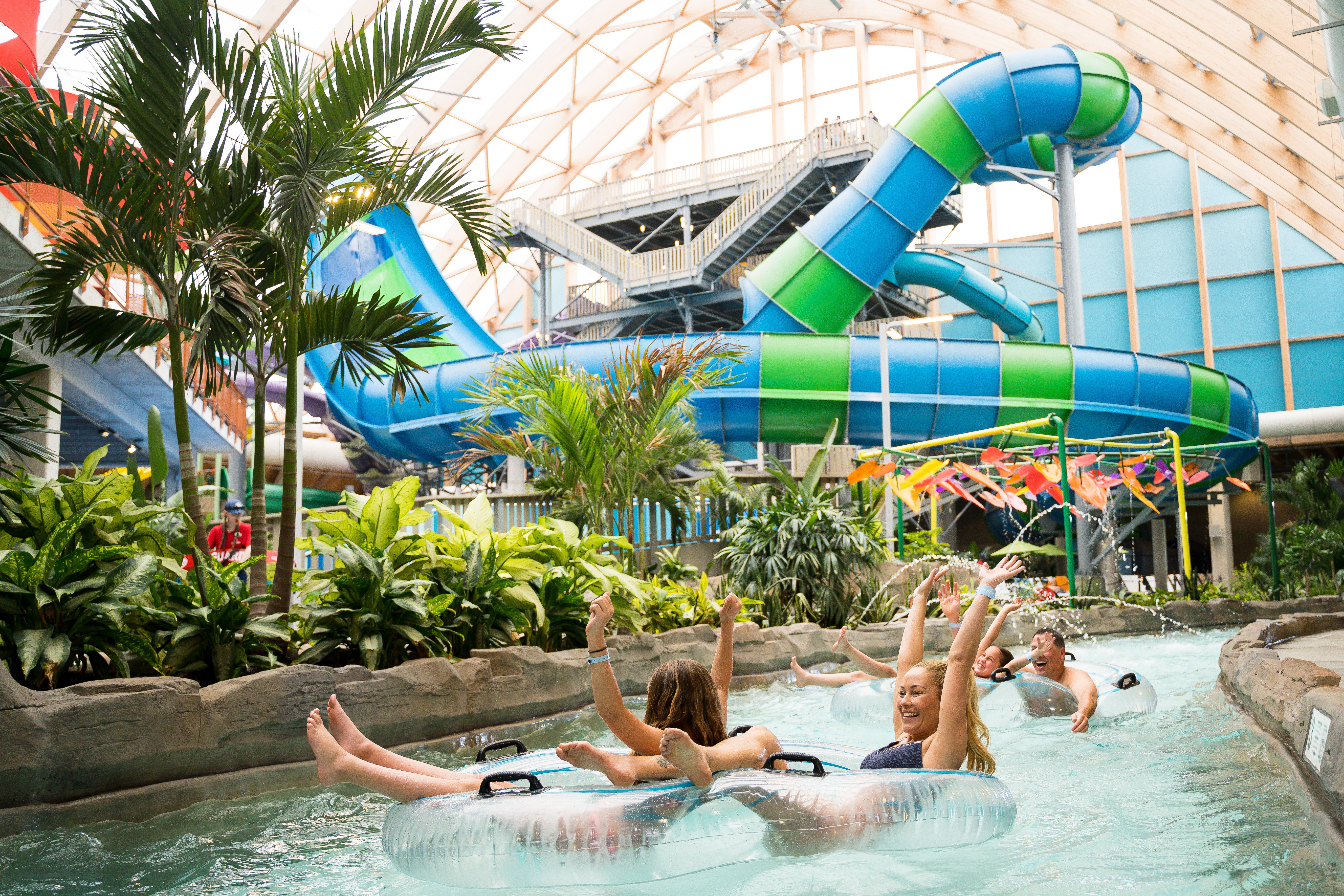 Four adults laugh as they ride the lazy river around Kartrite Water Park