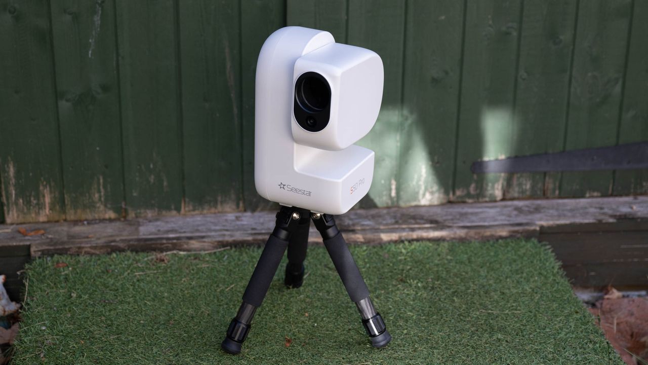 ZWO Seestar S50 Pro on a tripod against a green shed
