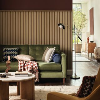 Living room with vertical slatted wood panelling and olive green sofa