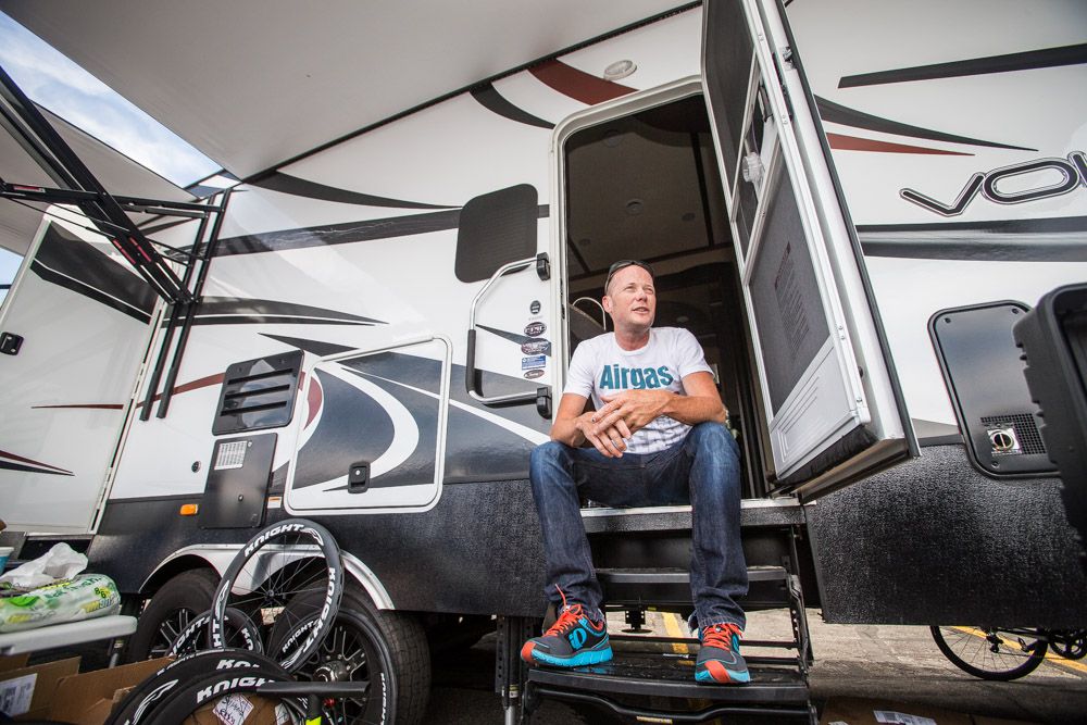 Chris Horner poses for a photo on the steps of the 40-foot RV he brings to races.