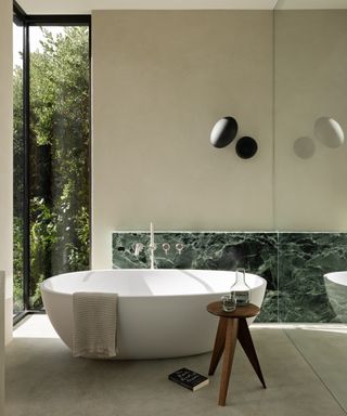 green marble bathroom with freestanding tub
