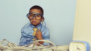 A small child in a smart shirt messing with wires