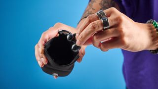 Skullcandy Push 720 Open in black and silver colorway with charging case photographed on a blue background