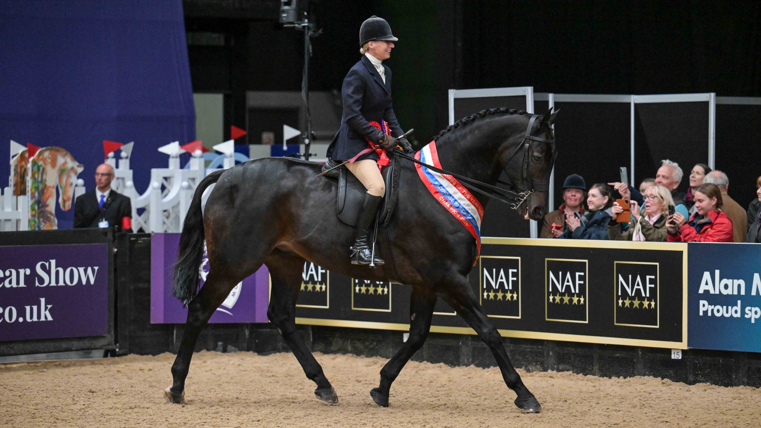 Rich Man Poor Man and Kirstine Douglas trot from the HOYS arena with the winners sash around his neck