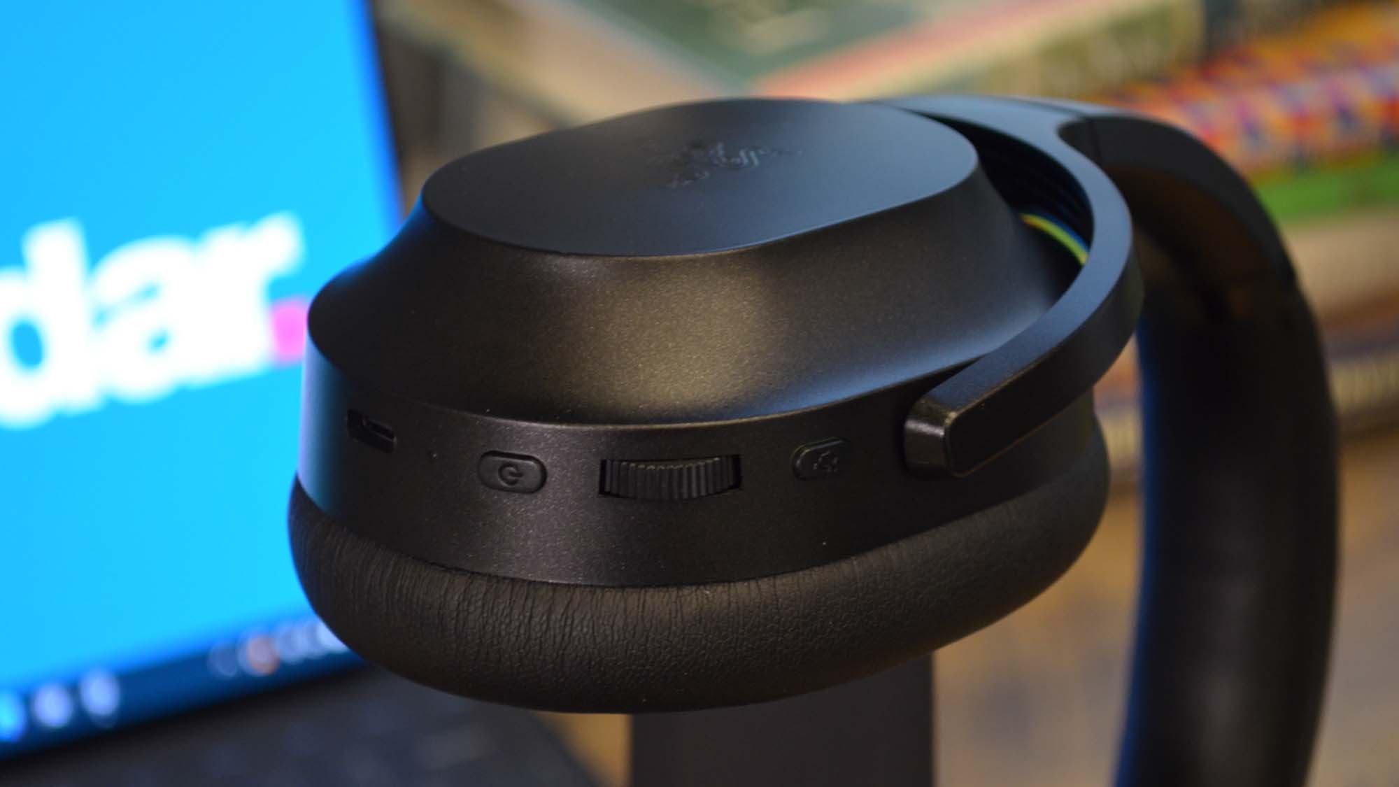 A Razer Barracuda Pro on a headset stand in front of a computer with the techradar logo on it