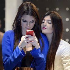 Two girls staring at a smart phone