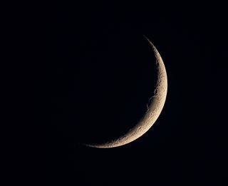 Very thin crescent moon in black sky