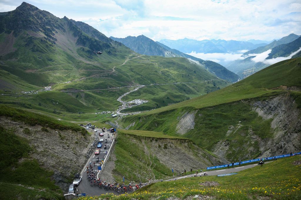 The pack of riders (peloton) cycles in the ascent of Col du Tourmalet during the 14th stage of the 111th edition of the Tour de France cycling race, 151,9 km between Pau and Saint-Lary-Soulan Pla d'Adet, in the Pyrenees mountains in southwestern France, on July 13, 2024. (Photo by Anne-Christine POUJOULAT / AFP)