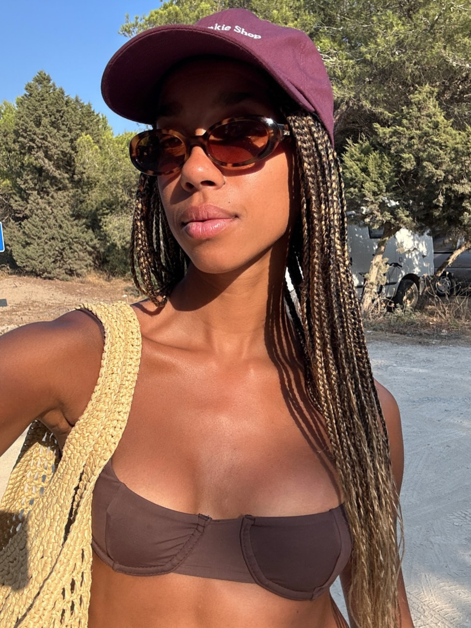 A woman with long braided hair walking in the sun