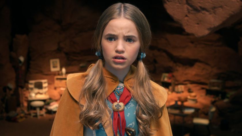 Holly in a blue dress, yellow cape and red scarf. 