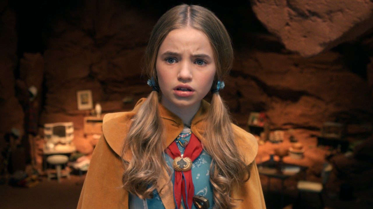 Holly in a blue dress, yellow cape and red scarf. 