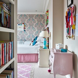 children's bedroom with book shelf and carpet flooring