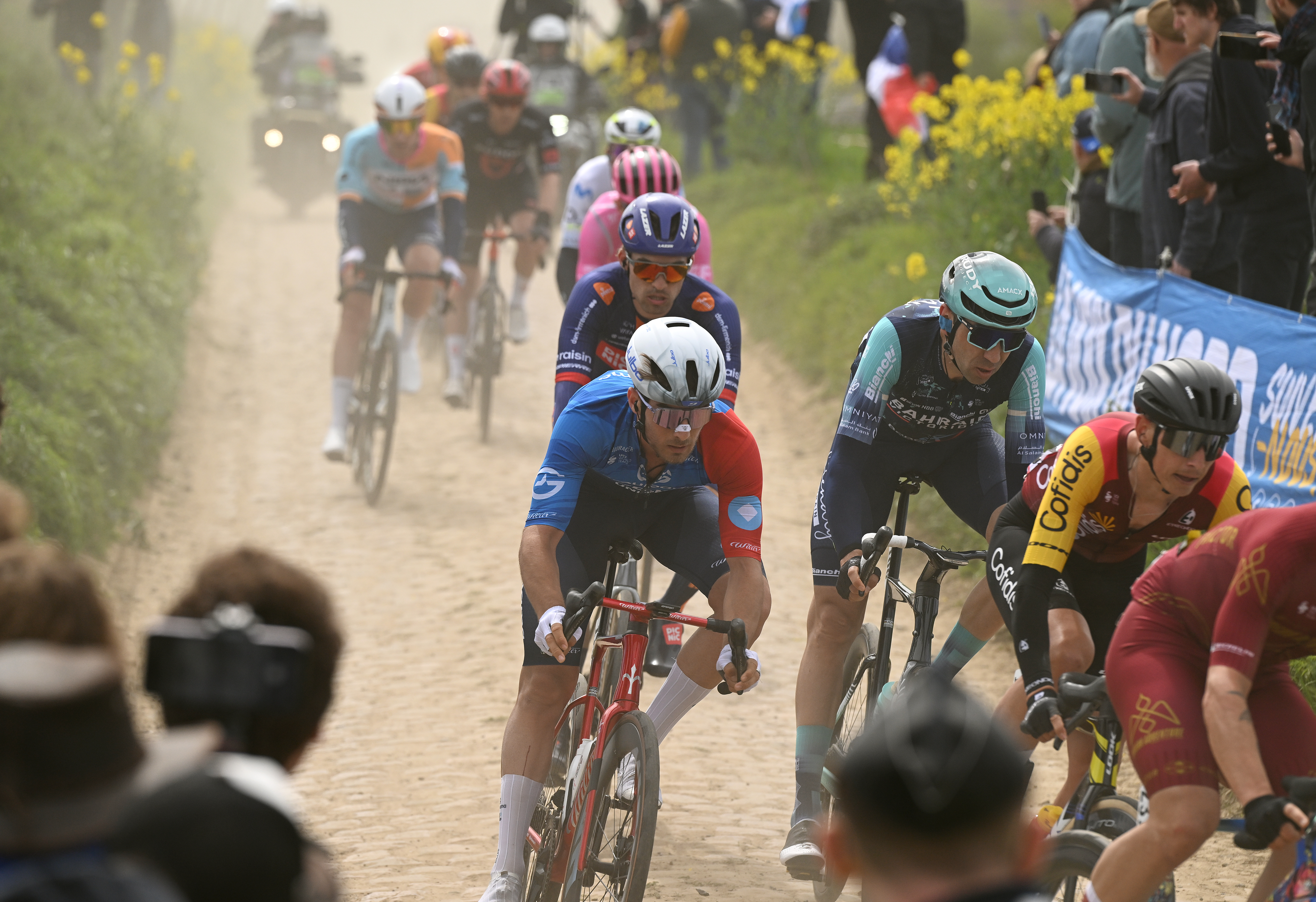 ROUBAIX, FRANCE - APRIL 12: (L-R) Titouan Fontaine of France and Team Groupama - FDJ United and Kamil Gradek of Poland and Team Bahrain - Victorious compete passing through the Troisvilles a Inchy cobblestones sector while fans cheer during the 123rd Paris-Roubaix Hauts-de-France 2026 - Men&amp;apos;s Elite a 258.3km one day race from Compiegne to Roubaix / #UCIWT / on April 12, 2026 in Roubaix, France. (Photo by Dario Belingheri/Getty Images)