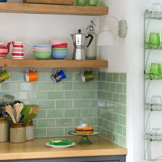 kitchen with green tiles and cups