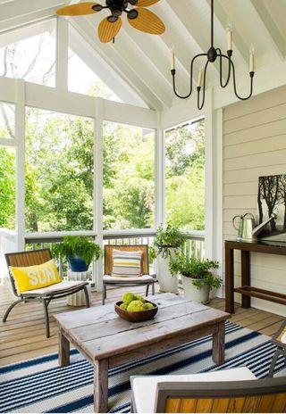 Coastal-inspired sunroom with table, chairs and rug
